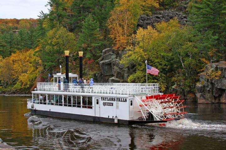 a boat floating along a river next to a body of water