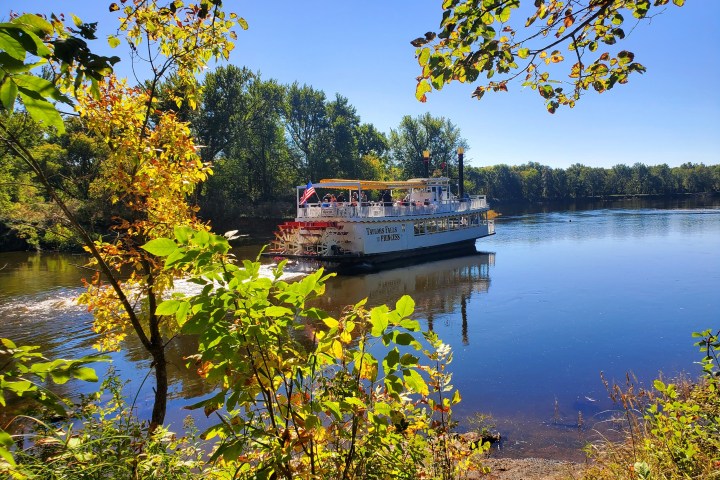 a small boat in a body of water surrounded by trees