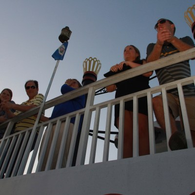 a group of people sitting next to a fence