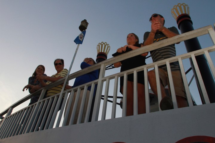 a group of people sitting next to a fence