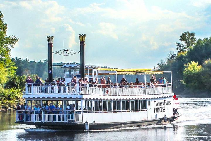 a boat floating along a river next to a body of water