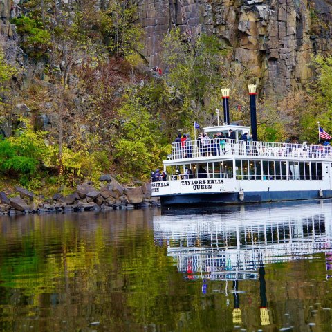 a boat floating along a river next to a body of water