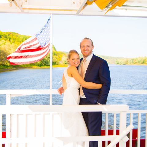 a man and a woman standing in front of a body of water