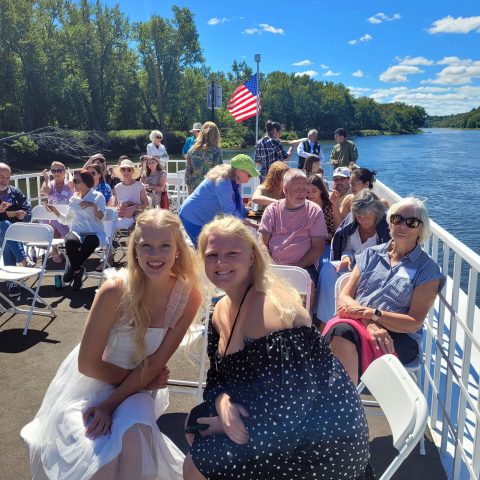 a group of people sitting next to a body of water