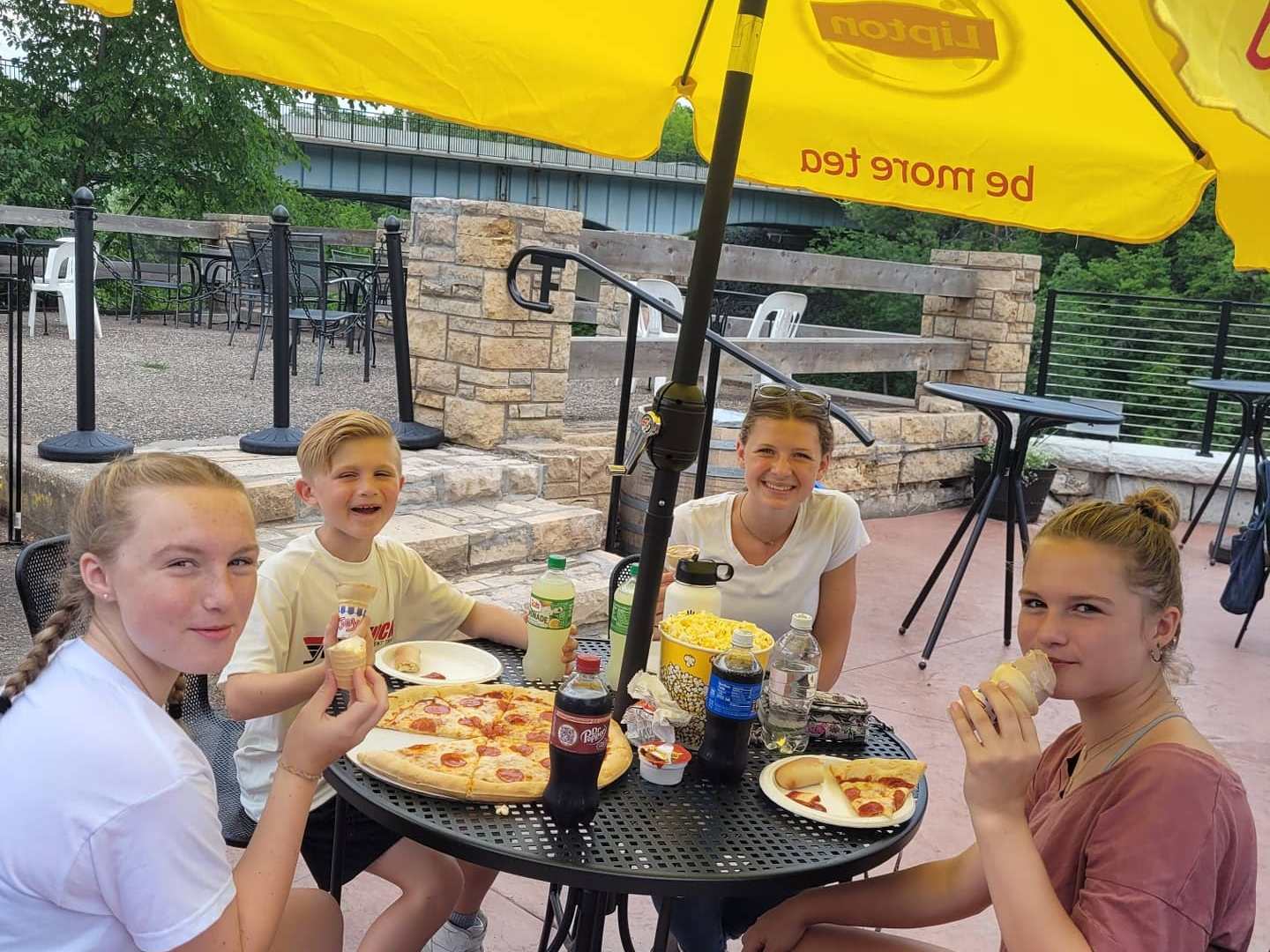 a group of people sitting at a table eating food