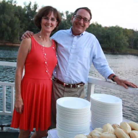a man and a woman standing in front of a cake