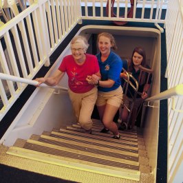 a girl sitting in front of a fence