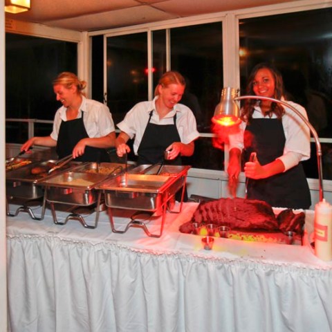 a group of people sitting at a table with a cake