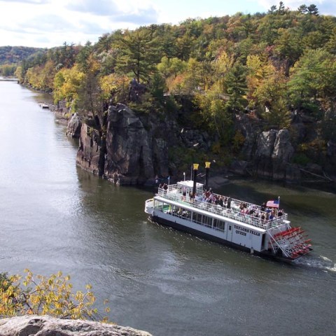 a boat traveling along a river next to a body of water