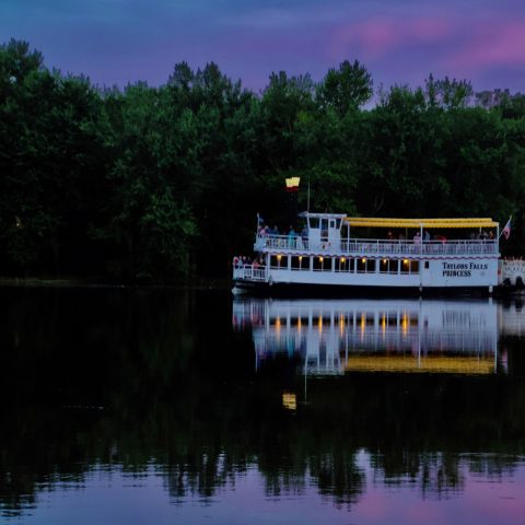 a boat traveling along a river next to a body of water