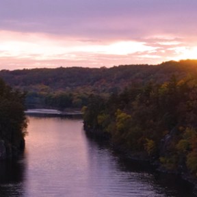 a bridge over a body of water with a mountain in the background