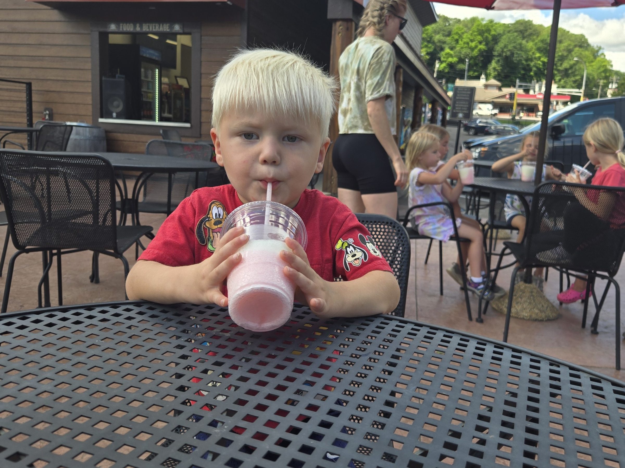 a little boy sitting at a table eating food