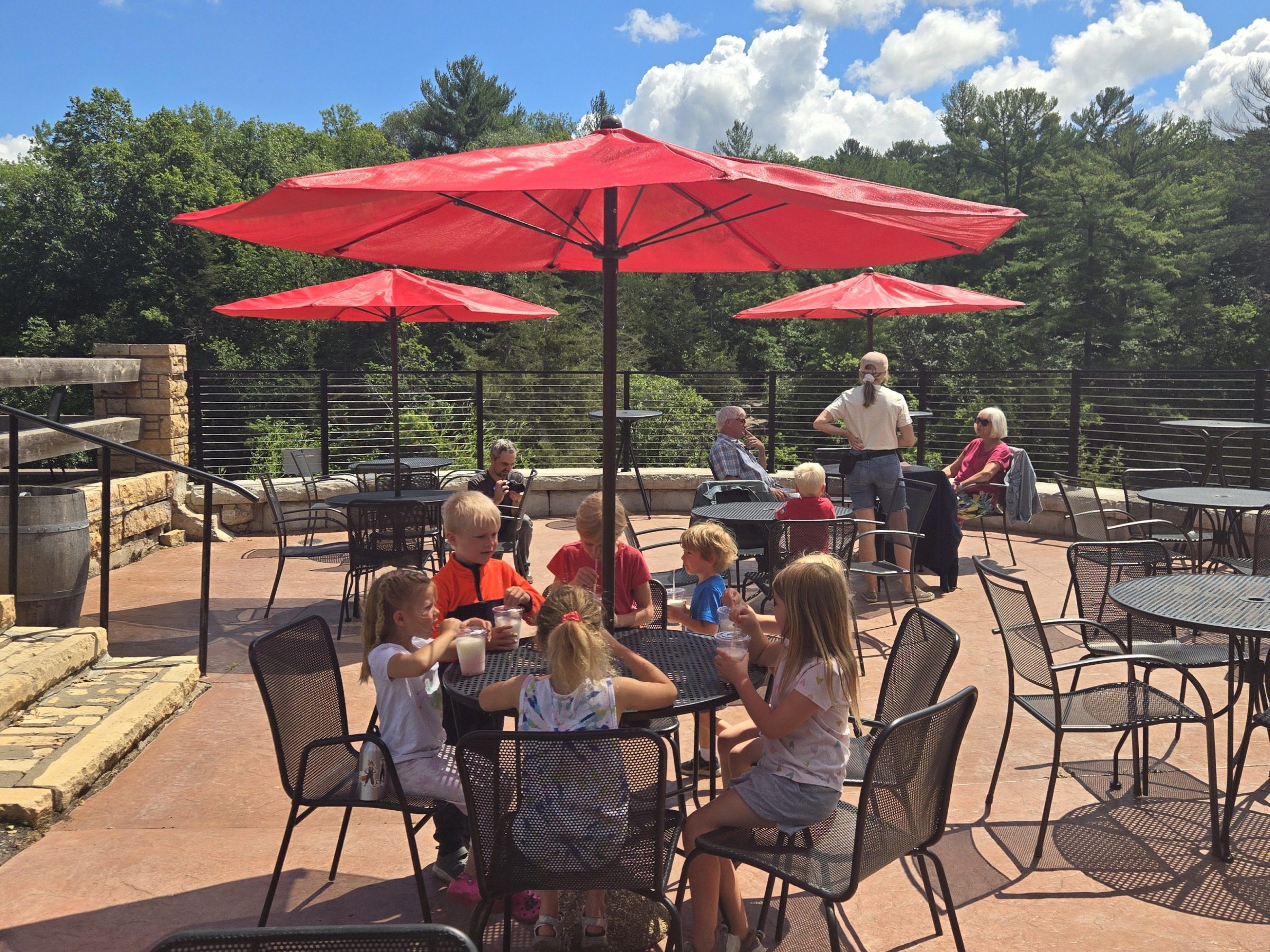 a group of people sitting around a dinner table umbrella