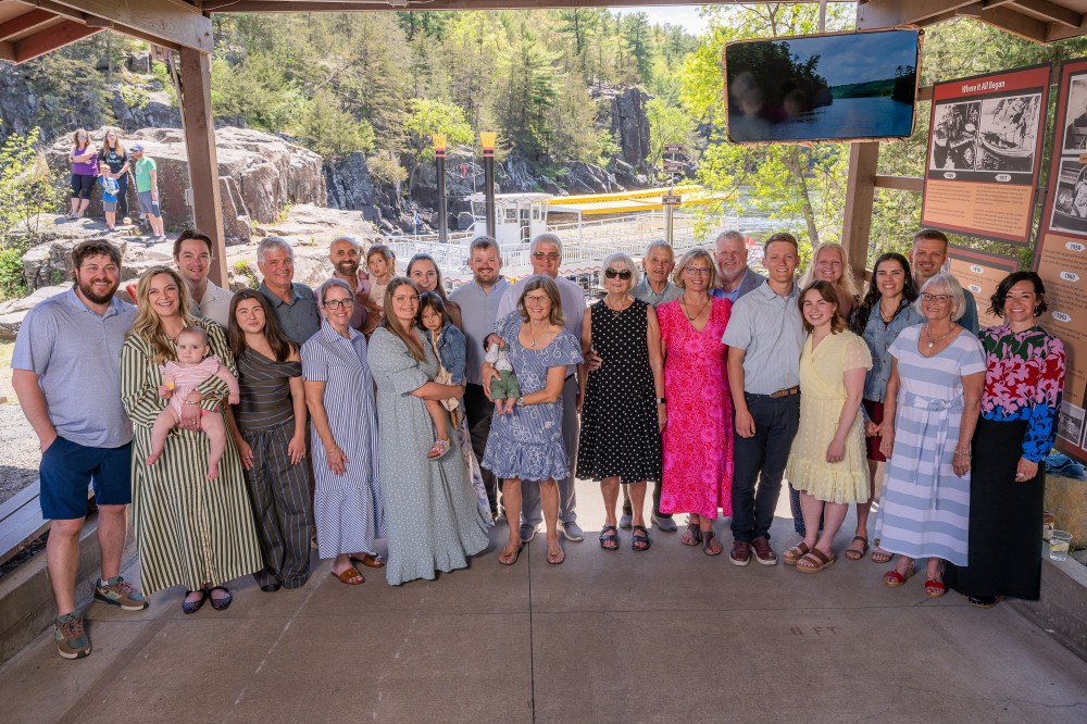 A group of people posing together at an outdoor park pavilion.